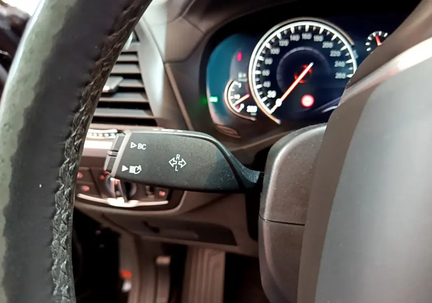 Vue rapprochée du commodo gauche et du tableau de bord éclairé du BMW X3 noir, version 2019 Luxury.