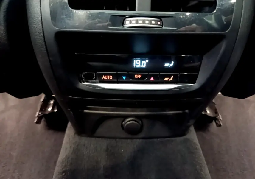 Gros plan sur la commande de climatisation arrière digitale affichant 19°C dans un BMW X3 noir 2019.