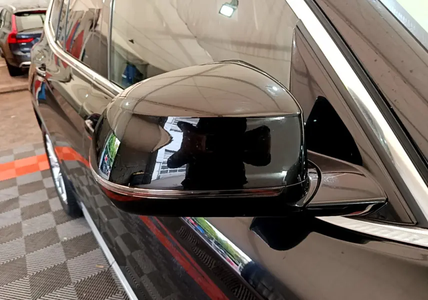 Rétroviseur côté gauche noir brillant d’un BMW X3 2019, avec reflet et entourage chromé visible.