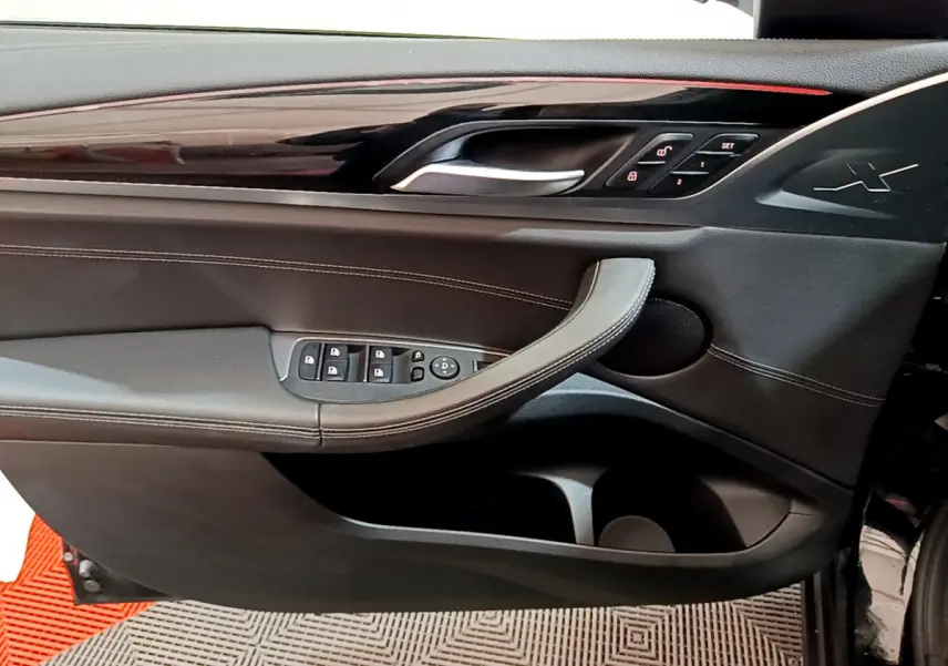 Intérieur côté gauche de la porte BMW X3 xDrive20d 2019 noire, avec commandes de vitres et insert brillant noir.