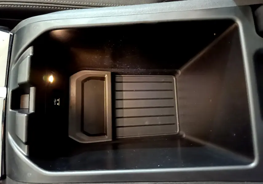 Vue plongeante sur le rangement central noir intérieur du BMW X3 xDrive20d 2019 avec prise USB et éclairage intégré.