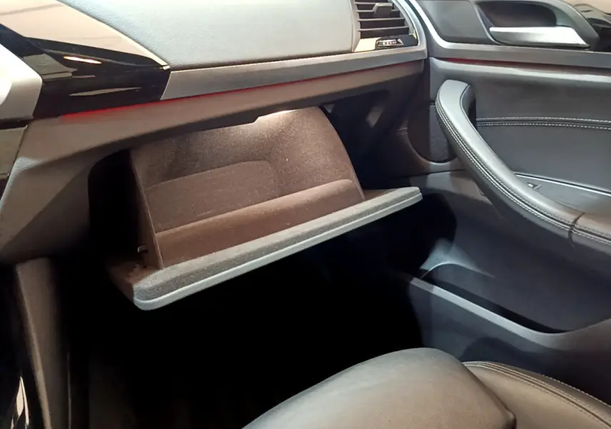 Intérieur noir du BMW X3 2019, vue côté passager avec boîte à gants ouverte et garnitures cuir visibles.