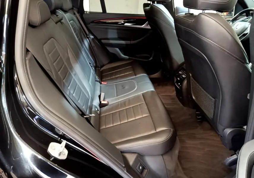 Vue intérieure côté gauche des sièges arrière en cuir noir du BMW X3 xDrive20d 2019 avec finitions Luxury.