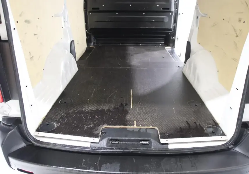 Vue arrière du fourgon blanc Citroën Jumpy XL 2019 montrant l'espace de chargement avec revêtement bois et attelage.