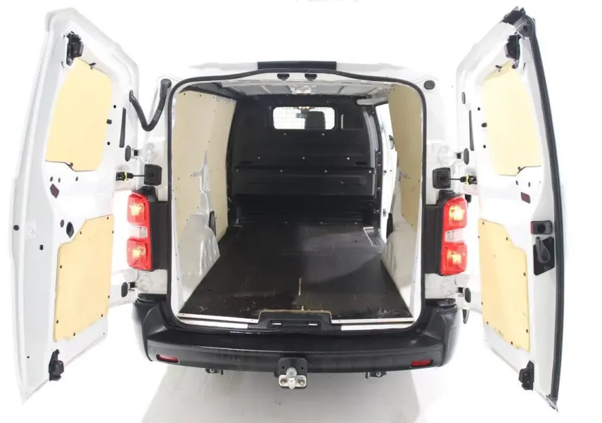 Vue arrière du Citroën Jumpy blanc avec portes ouvertes montrant l'intérieur utilitaire équipé d'un kit bois et attelage.