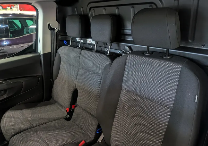 Vue intérieure des sièges avant en tissu gris foncé du Toyota Proace City Long 2026, avec appuie-têtes et ceinture visible côté gauche.