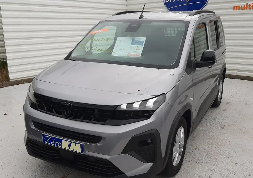 Peugeot Rifter gris acier en 3/4 avant droit, avec calandre noire et jantes alu 16 pouces visibles.