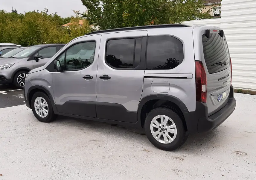 Peugeot Rifter gris acier vu de trois quarts arrière droit, avec vitres arrière surteintées et jantes alu 16 pouces.