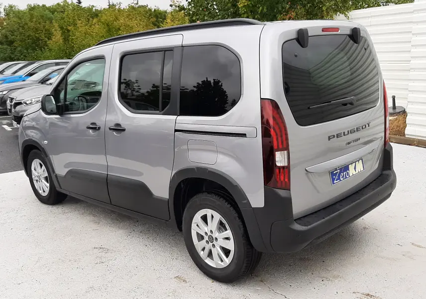 Vue 3/4 arrière droite du Peugeot Rifter gris acier avec vitres surteintées et jantes alu 16 pouces.