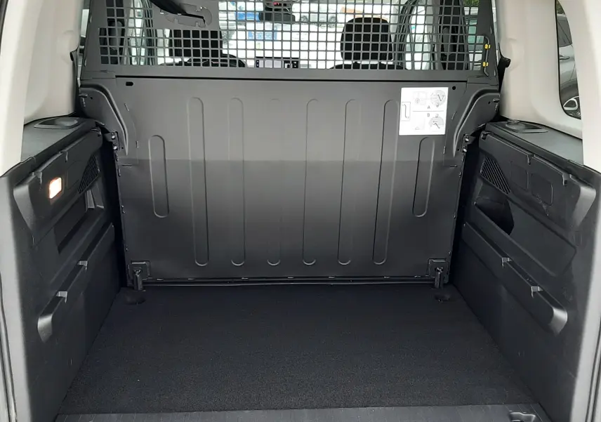 Vue arrière du coffre spacieux et vide du Peugeot Rifter gris acier, avec cloison métallique de séparation visible.