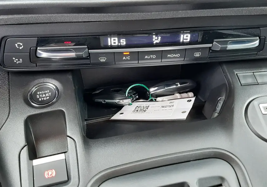 Détail de la console centrale du Peugeot Rifter gris acier 2026, montrant les commandes de climatisation et le bouton start/stop.