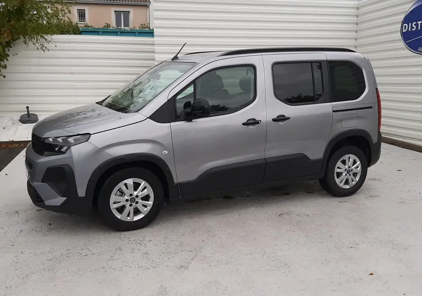 Peugeot Rifter gris acier vu de profil côté gauche, avec porte coulissante et jantes alu 16 pouces.