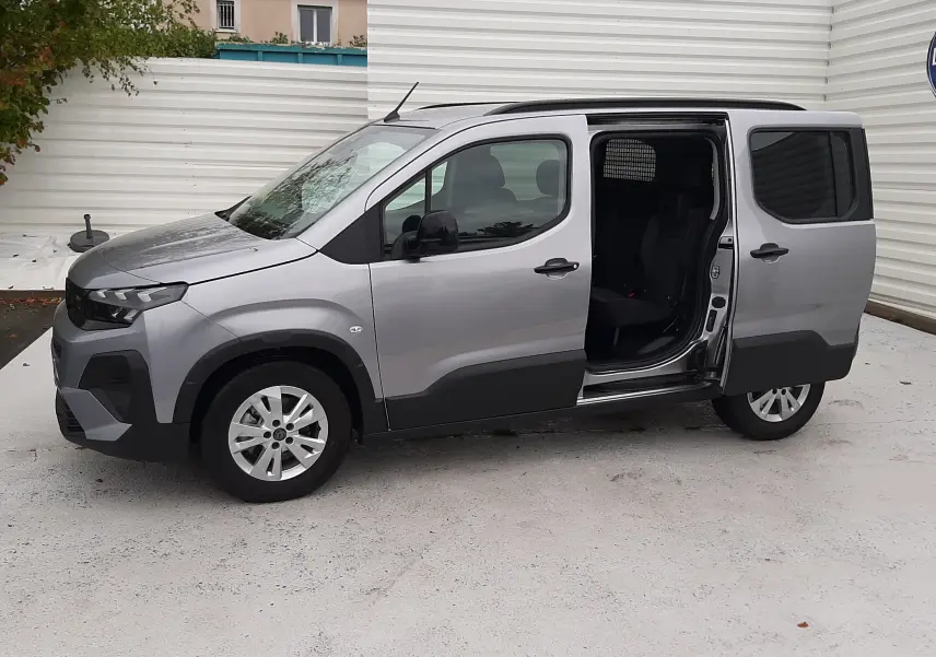 Peugeot Rifter gris acier vu de profil gauche, porte latérale coulissante ouverte, jantes alu 16 pouces visibles.