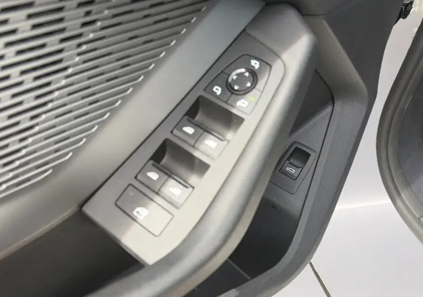 Gros plan sur les commandes des vitres et rétroviseurs côté conducteur d'une BMW Série 1 blanche, intérieur noir.