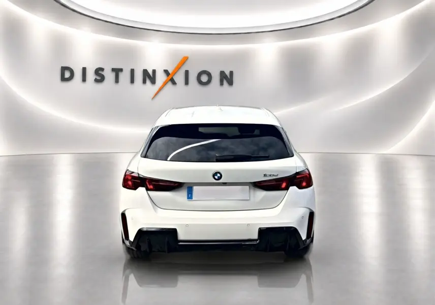 Vue arrière d'une BMW Série 1 blanche pure (120da M Sport) dans un showroom lumineux avec logo Distinxion.