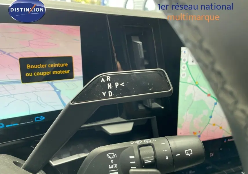 Le levier de boîte automatique du Renault Austral E-Tech rouge passion, vu de près avec l'écran tactile en arrière-plan.