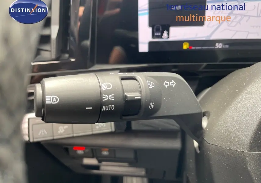 Gros plan sur la commande des feux et clignotants à gauche du volant dans le Renault Austral E-Tech hybride 2025.