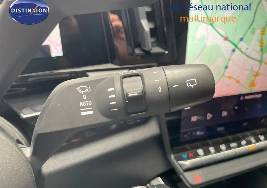 Gros plan sur la commande d'essuie-glace droite du Renault Austral E-Tech rouge passion, avec écran tactile et GPS en arrière-plan.