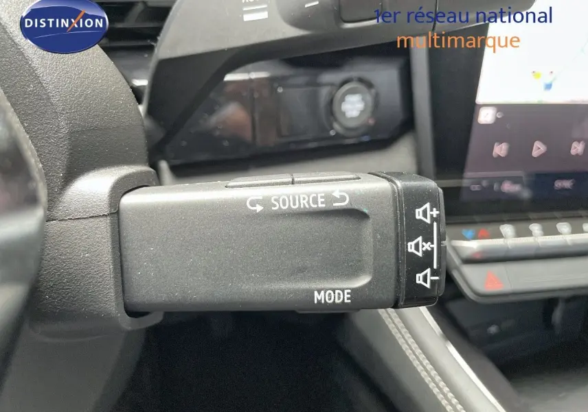 Gros plan sur la commande au volant du Renault Austral E-Tech rouge passion avec toit noir, montrant les boutons source et mode.