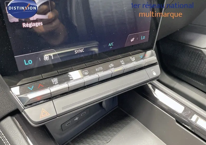 Détail de la console centrale avec commandes climatisation et écran tactile dans le Renault Austral E-Tech rouge passion.