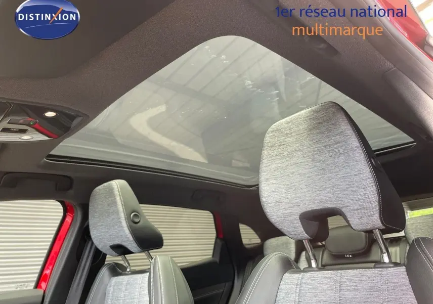 Vue intérieure du Renault Austral E-Tech hybride 2025, sièges gris clair et toit panoramique en verre.