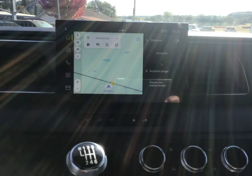 Gros plan sur l'écran tactile GPS et le levier de vitesses manuel du Renault Master blanc 2025, intérieur lumineux.