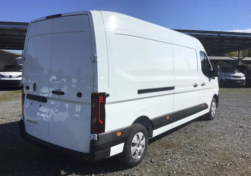 Renault Master blanc vu en 3/4 arrière droit, fourgon utilitaire avec feux arrière LED et protections latérales noires.