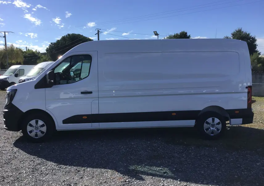 Profil côté gauche d’un fourgon blanc Renault Master L3H2 2025 avec protections latérales noires et jantes acier.