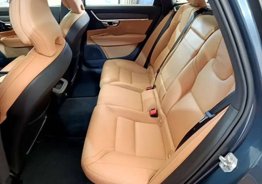 Vue côté droit de l'intérieur arrière du Volvo V90 Cross Country 2019 avec sièges en cuir beige et portières bleu foncé.