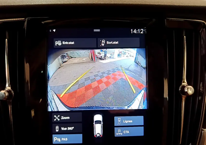 Écran tactile intérieur montrant la caméra de recul avec guidage et vue arrière du Volvo V90 Cross Country bleu.