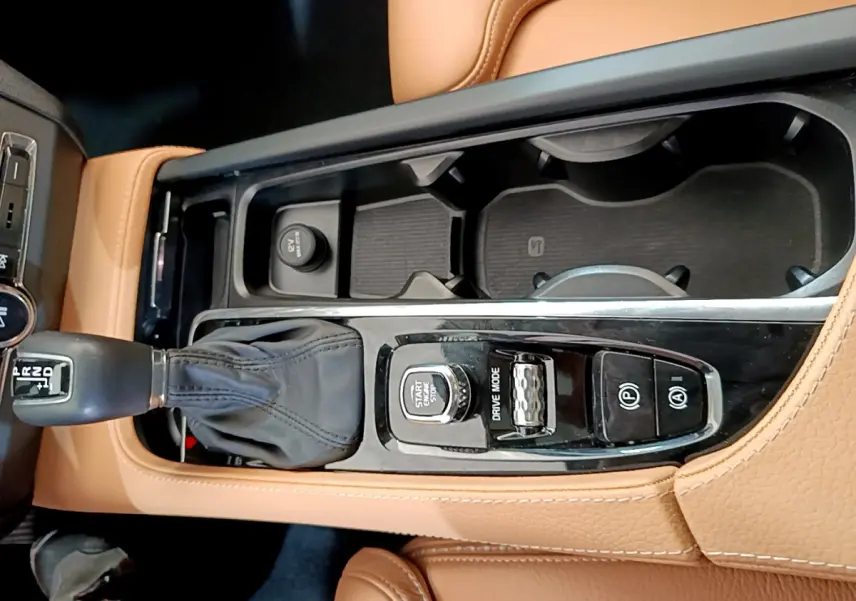 Vue plongeante sur la console centrale cuir beige du Volvo V90 Cross Country 2019 avec levier de vitesse et commandes.