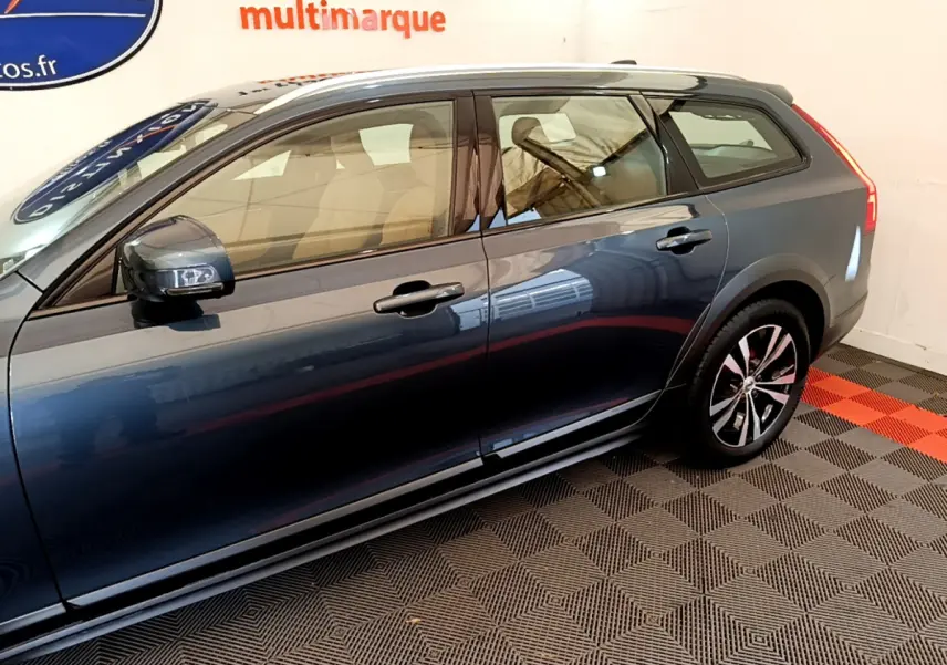 Vue latérale droite d'un Volvo V90 Cross Country bleu avec jantes alliage et rétroviseurs noirs.