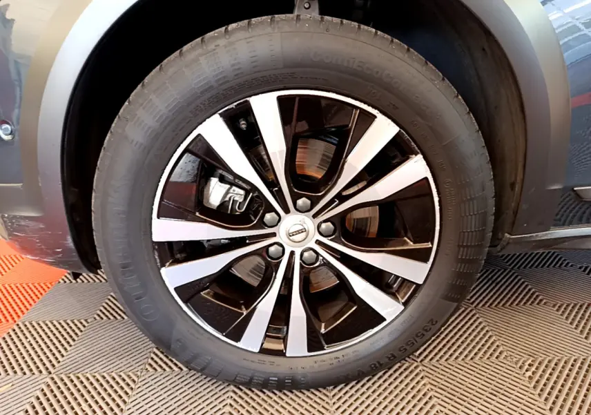 Gros plan sur la roue avant droite avec jante alliage bicolore du Volvo V90 Cross Country bleu 2019.