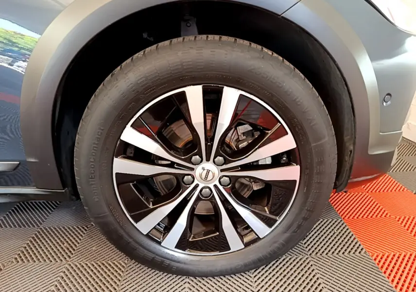 Gros plan sur la roue avant droite avec jante alliage bicolore du Volvo V90 Cross Country bleu 2019.