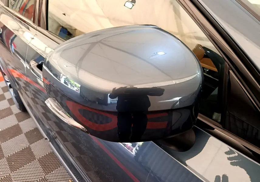 Rétroviseur côté gauche bleu brillant du Volvo V90 Cross Country 2019, avec reflet et partie de la portière visible.