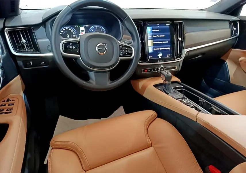Intérieur de Volvo V90 Cross Country 2019 vu de face, avec sièges cuir marron et tableau de bord noir moderne.