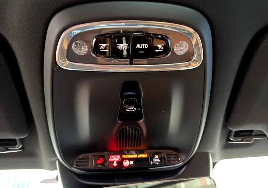 Vue intérieure du plafonnier noir avec commandes d'éclairage et indicateurs lumineux du Volvo V90 Cross Country bleu.