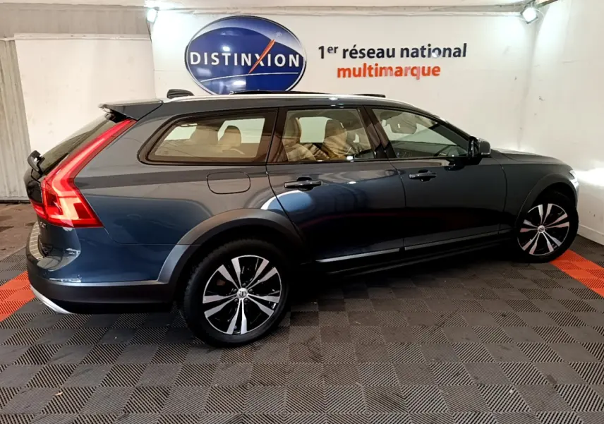 Vue latérale droite d’un Volvo V90 Cross Country bleu avec jantes alliage et feux arrière LED distinctifs.