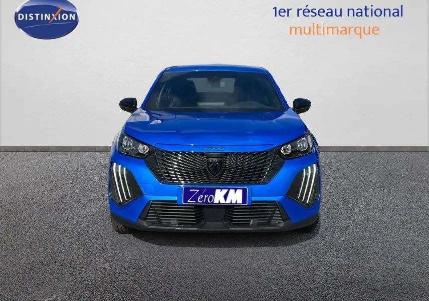 Vue frontale d'un Peugeot 2008 bleu Vertigo Metal avec calandre noire et feux LED verticaux allumés.