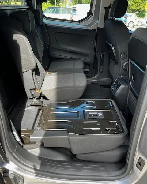 Vue intérieure côté droit du Peugeot Rifter gris foncé 2024, siège arrière rabattable mettant en valeur l'espace modulable.