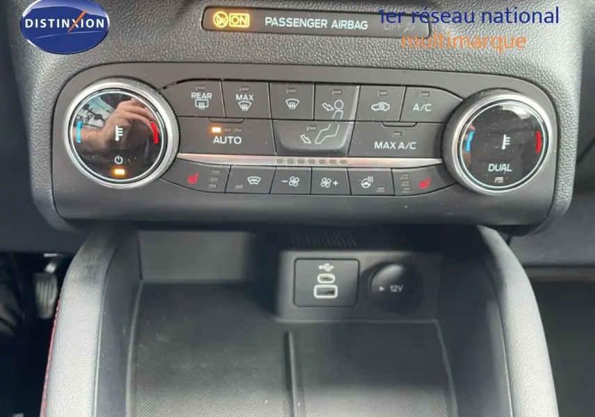 Détail de la console centrale du Ford Kuga 2024, montrant les commandes de climatisation et ports USB en intérieur noir.