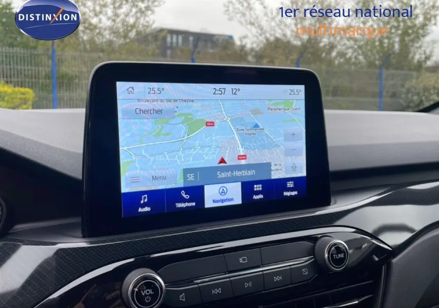 Écran tactile de navigation du Ford Kuga 2024, affichant une carte avec options audio et téléphone, intérieur noir.