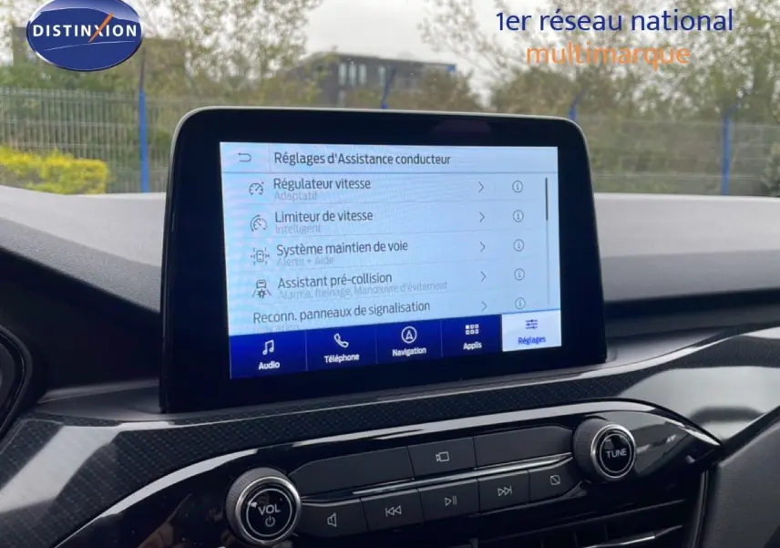 Vue intérieure du tableau de bord du Ford Kuga 2024 avec écran tactile affichant les réglages d’assistance conducteur.