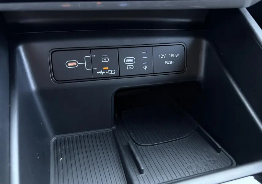 Gros plan sur la console centrale du Hyundai Tucson 2025 en Ecotronic Gray, montrant ports USB et prise 12V.