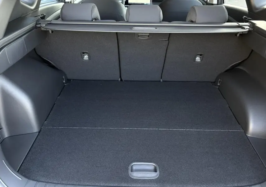 Coffre spacieux vu de l'intérieur arrière du Hyundai Tucson 2025, avec cache-bagages et revêtement noir.