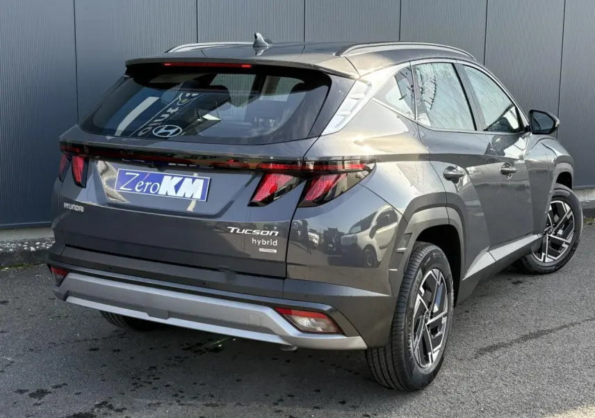 Vue 3/4 arrière droite du Hyundai Tucson 2025 gris Ecotronic avec feux arrière LED et jantes alliage 17 pouces.