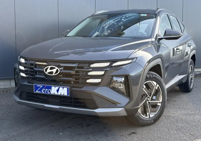 Hyundai Tucson 2025 Ecotronic Gray en 3/4 avant droit avec calandre noire et jantes alliage 17 pouces.