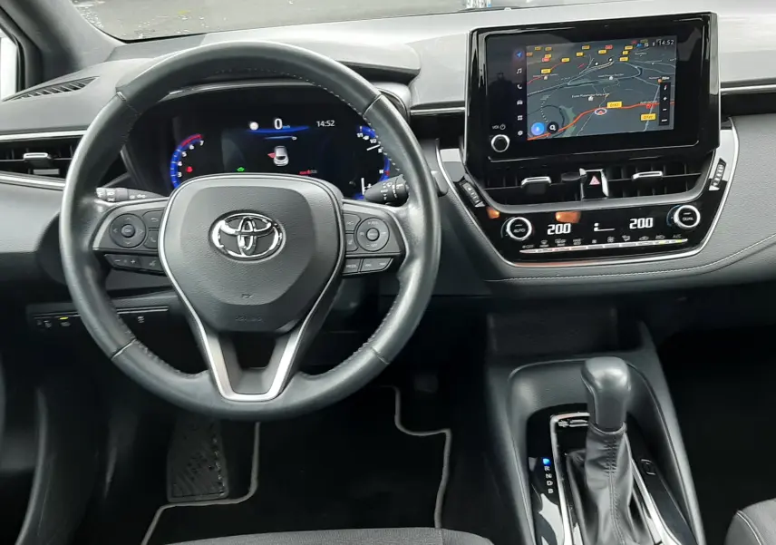 Vue intérieure du tableau de bord de la Toyota Corolla 122 CH Dynamic 2022, avec volant, écran tactile et levier de boîte auto.