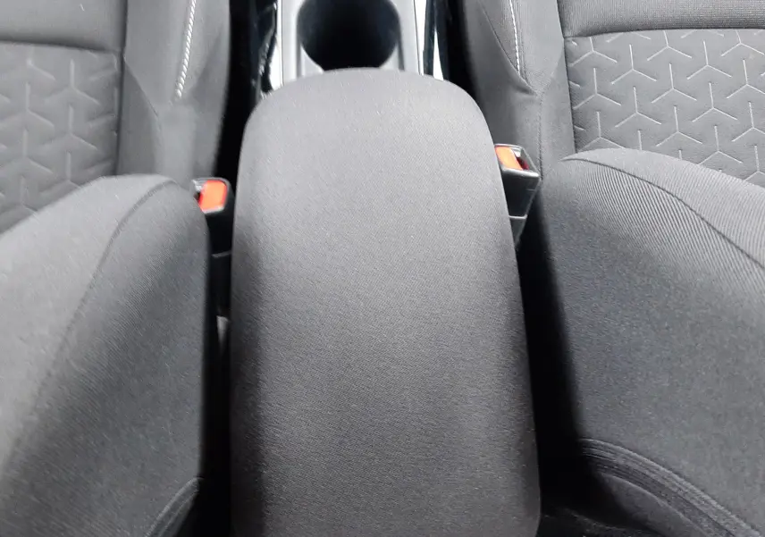 Vue plongeante sur l'accoudoir central et les sièges en tissu gris foncé de la Toyota Corolla 122 CH Dynamic 2022.