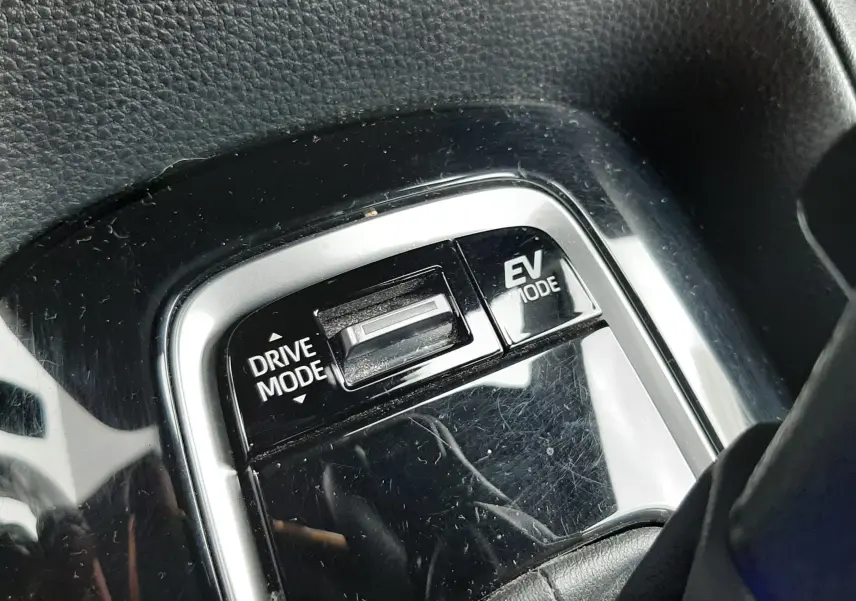 Gros plan sur le sélecteur de modes de conduite noir brillant de la Toyota Corolla blanche hybride 2022.